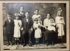31Family Photo 1921Roxanne BocyckOnondaga CountyThis photo is of my 18 year old grandmother (standing) along with her brother, his wife, and six children. My grandmother and her brother immigrated from Poland to America in the early 1900s. I am currently writing a novel about her journey from Poland, an arranged marriage, and a possible murder! Or was it self-defense? Either way, I am enjoying the process of "finding her roots".