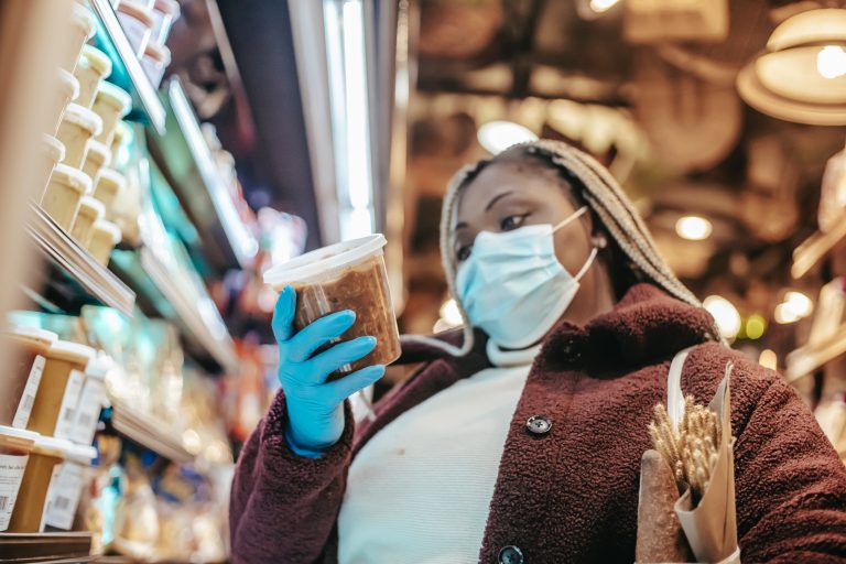 A shopper with a mask goes through a grocery store.